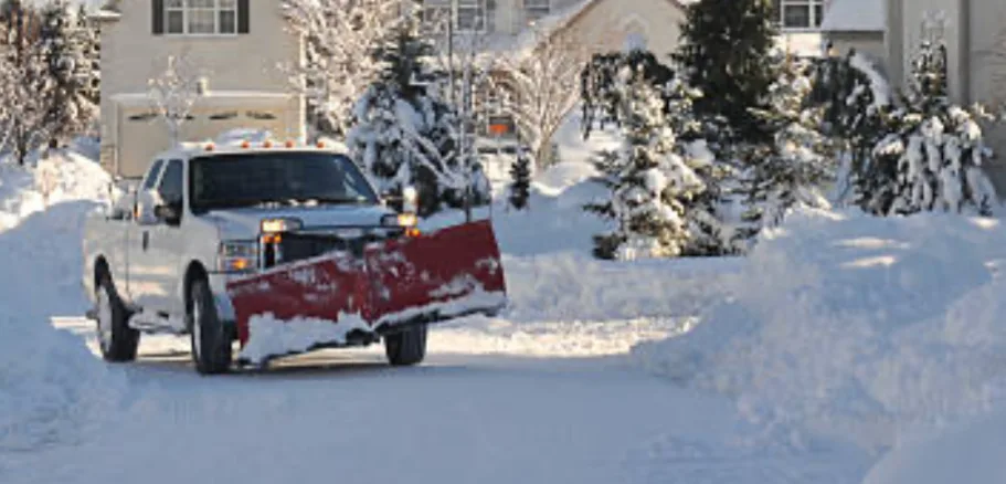 An ETA Outdoor Services Snow Plow Truck Plowing A Residential Customers Driveway