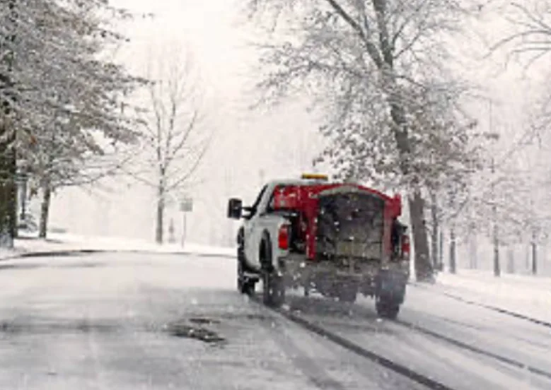An ETA Outdoor Services Salt Truck On Route For Snow Plowing And Ice Management Service AT A Commercial Customers Parking Lot